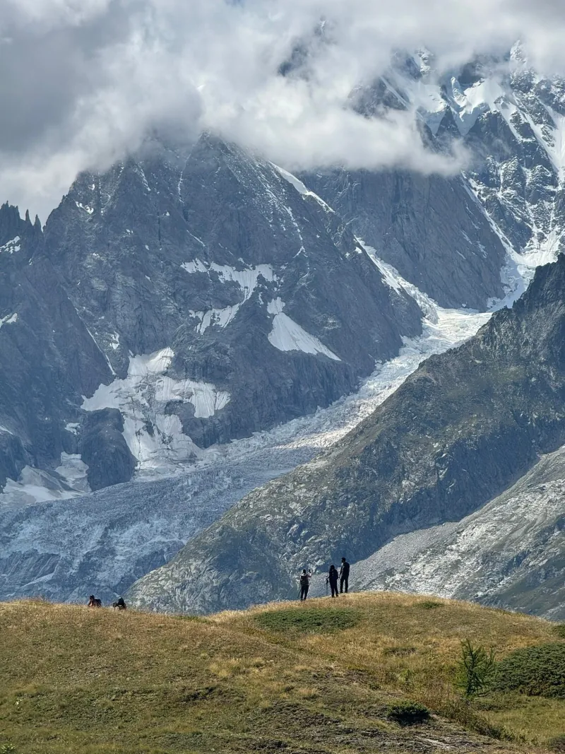 The path climbing through alpine meadow towards a high col
